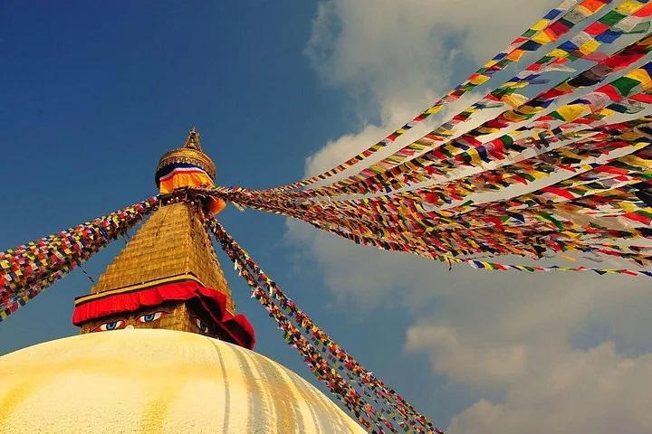 Bunte Gebetsfahnen spannen sich von der Spitze des Boudhanath-Stupa.